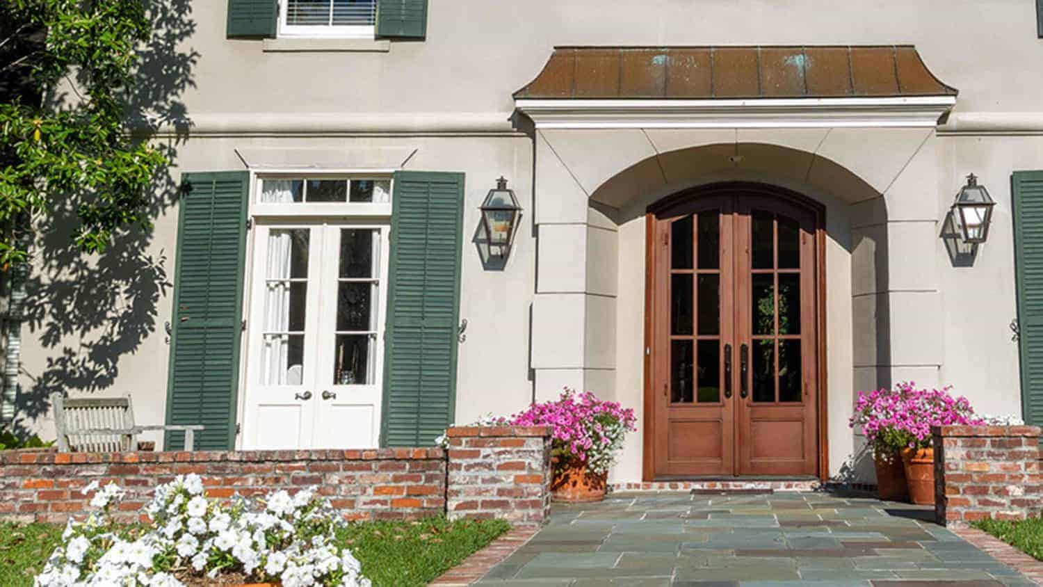 Wooden front doors with glass panels on a two story home