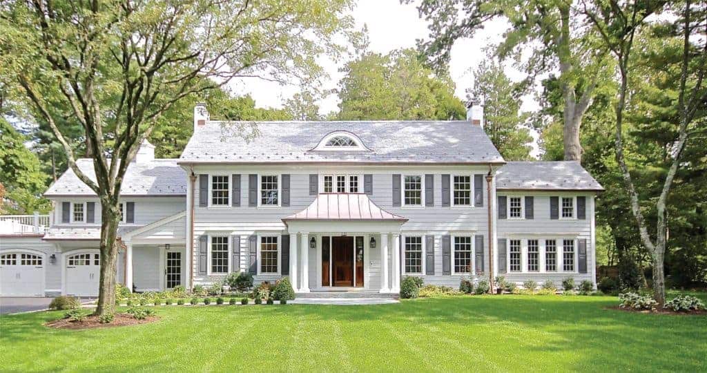 Large two-story white home with white siding and several windows