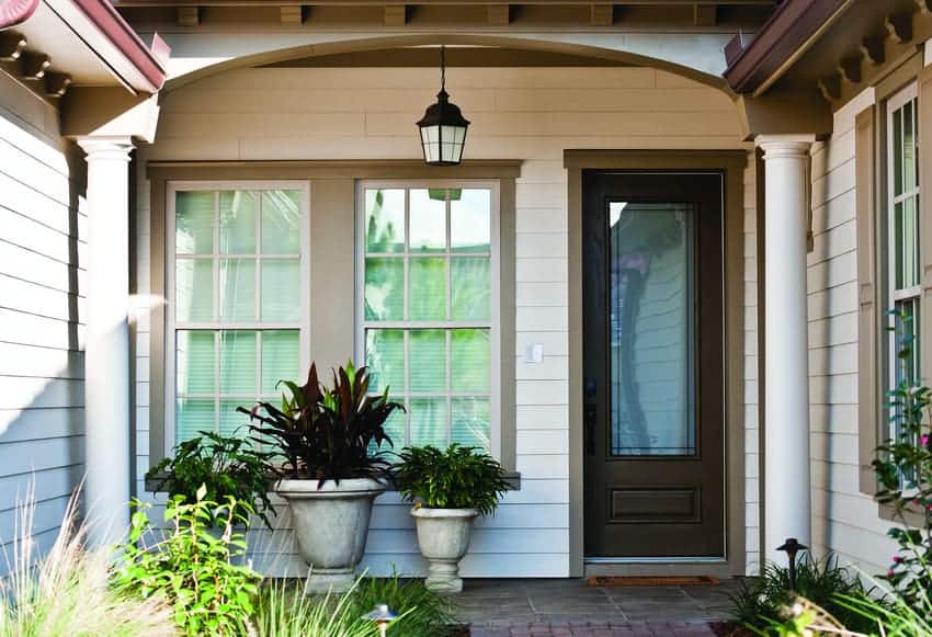View of front porch with arched covering on a home with fresh white siding