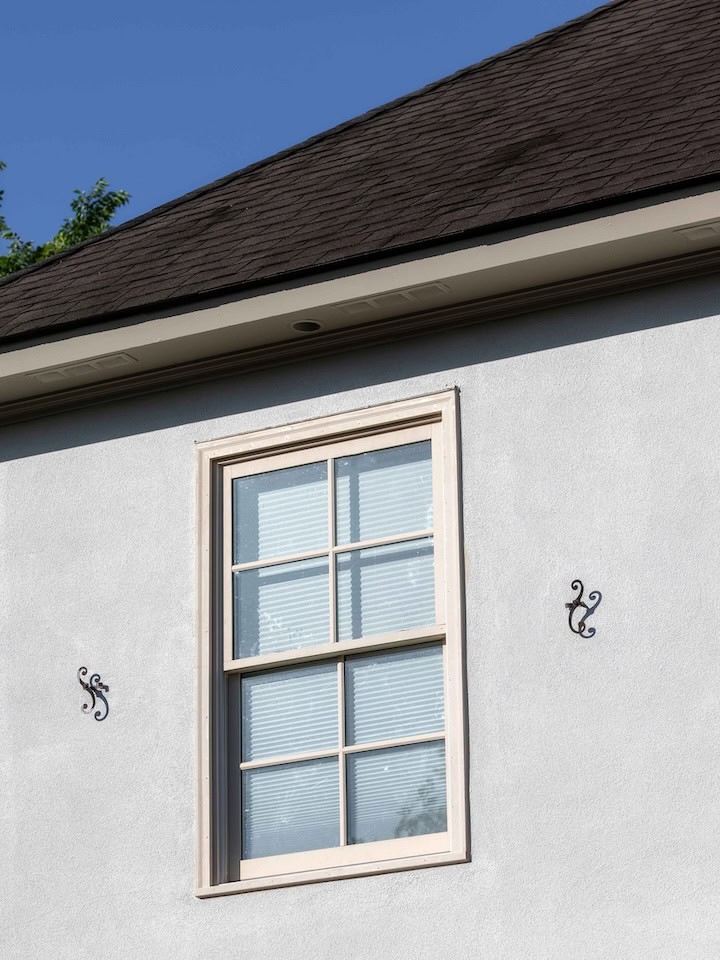 Close up view of a double-hung window on a stucco textured home