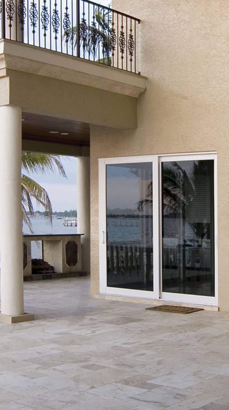 Sliding glass doors on a tan textured building by the water
