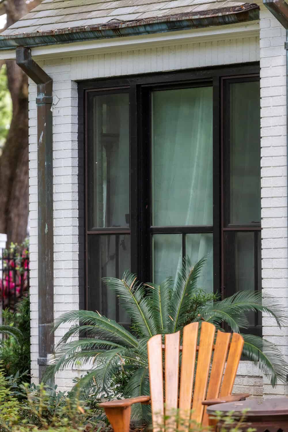 Black framed 3-lite end vent windows on a house with white siding